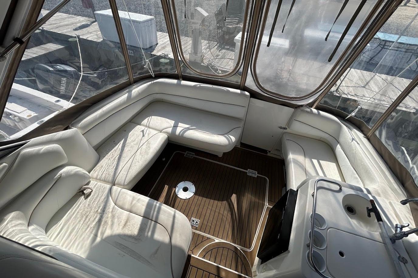 2001 Larson Cabrio 330 boat interior with white seating and wooden flooring.