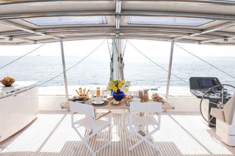Sinata Yacht Photos Pics Luxurious Sunreef 60 yacht deck with elegant dining setup, ocean view, and modern helm.