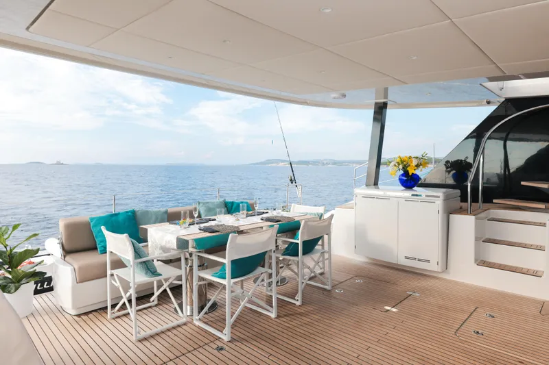 Sinata Yacht Photos Pics Luxurious Sunreef 60 yacht deck with dining area, ocean view, and elegant decor, 2019 model.