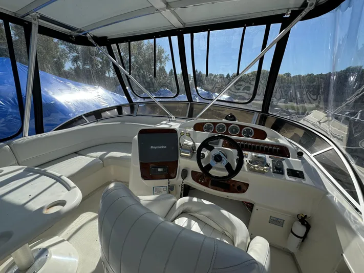 Baby Cake Yacht Photos Pics 2004 Meridian 381 Sedan boat cockpit with steering wheel, navigation controls, and seating.