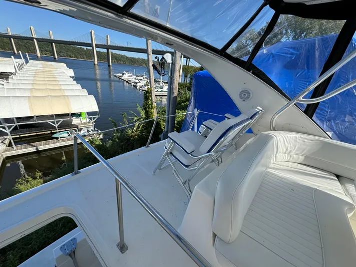 Baby Cake Yacht Photos Pics 2004 Meridian 381 Sedan yacht with white seating, docked near a bridge and marina.