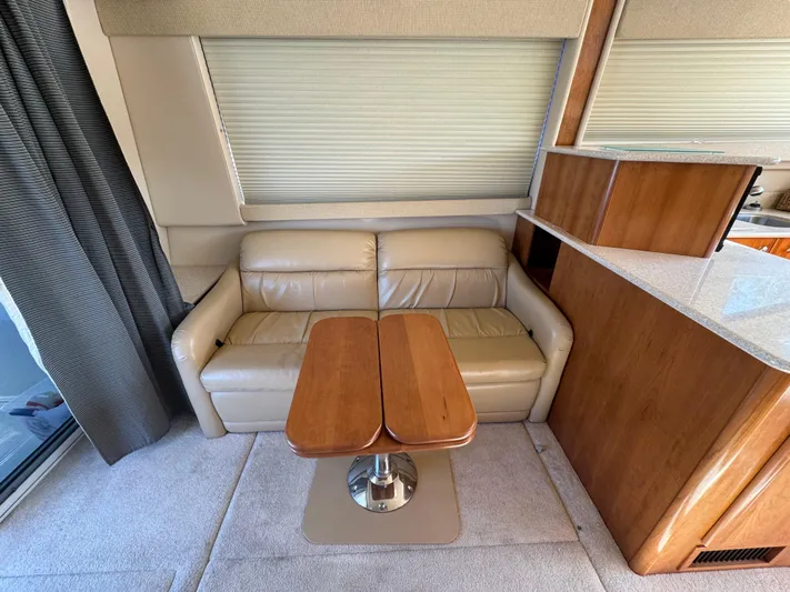 Baby Cake Yacht Photos Pics Interior of 2004 Meridian 381 Sedan with beige leather sofa and wooden table.