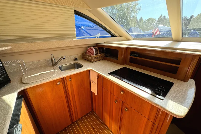 Baby Cake Yacht Photos Pics Luxurious kitchen interior of 2004 Meridian 381 Sedan yacht with wooden cabinetry and modern appliances.