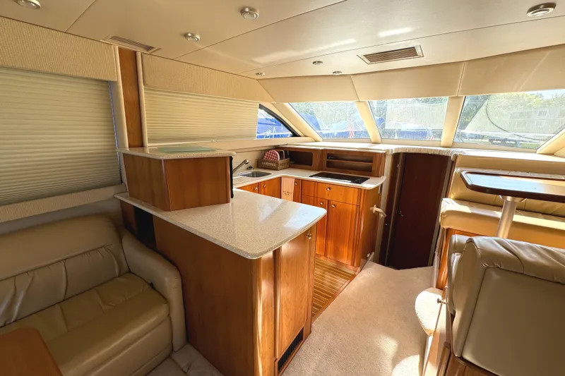 Baby Cake Yacht Photos Pics Luxurious interior of a 2004 Meridian 381 Sedan yacht with modern kitchen and seating area.