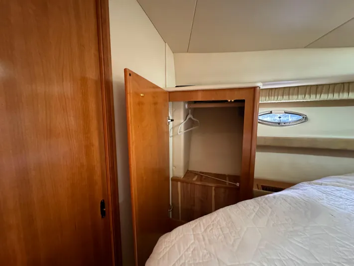 Baby Cake Yacht Photos Pics Interior of 2004 Meridian 381 Sedan with open wooden closet and bed.