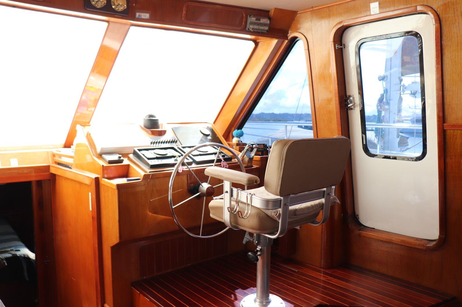 Pilot cabin of 2010 Alpha 50 boat with wooden interior and steering wheel.