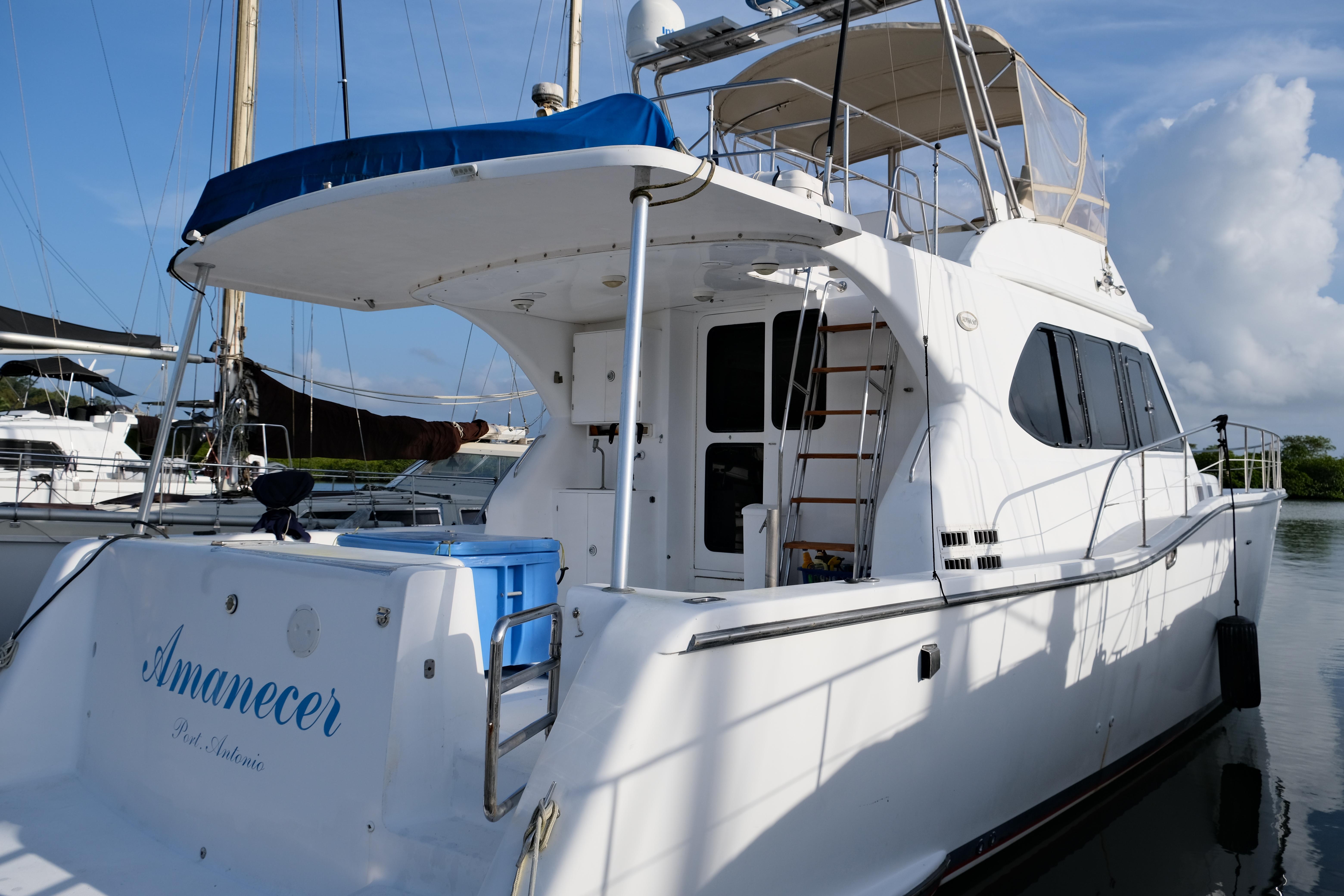 Luxury yacht docked at marina, Alpha 50 model, 2010, with spacious upper deck.