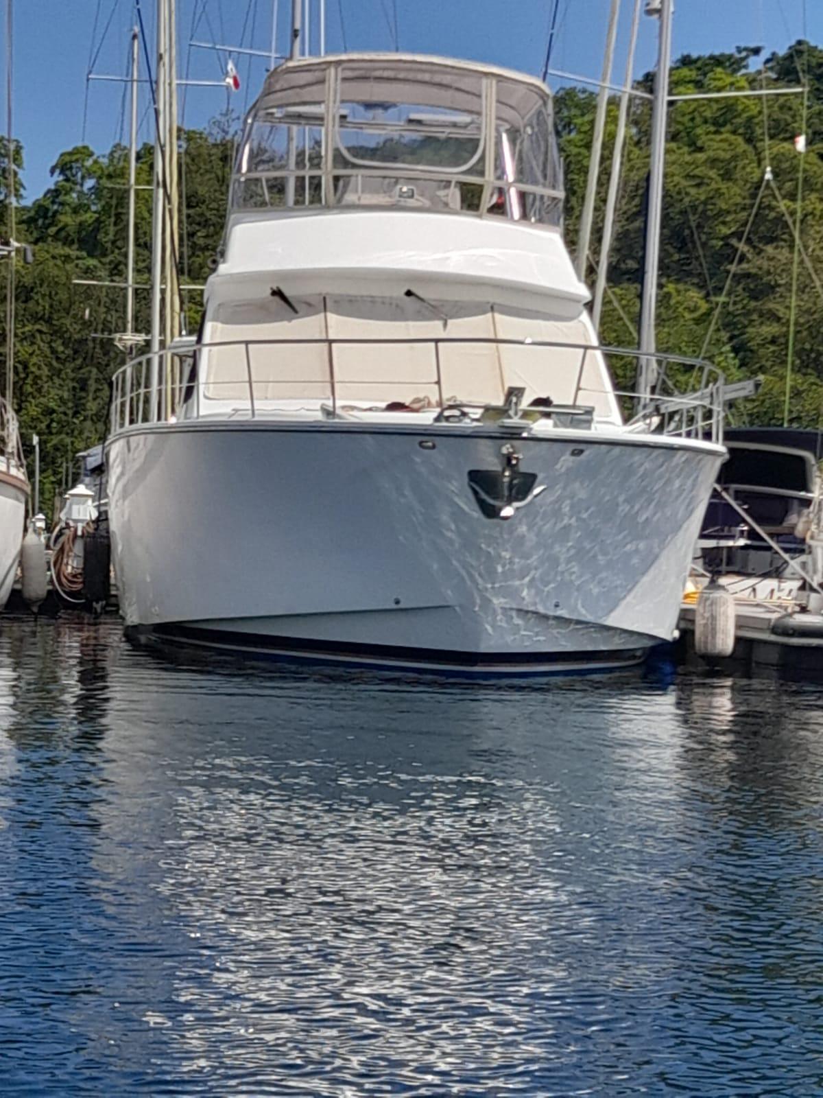 Luxury yacht Alpha 50, 2010 model, docked in a serene marina setting.
