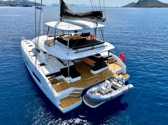  Yacht Photos Pics 2023 Lagoon 55 yacht with tender, sailing in clear blue waters.