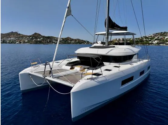  Yacht Photos Pics 2023 Lagoon 55 catamaran sailing on calm blue waters, showcasing sleek design and spacious deck.