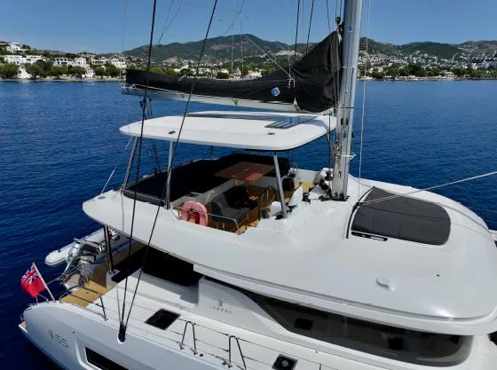  Yacht Photos Pics 2023 Lagoon 55 yacht on serene blue water, featuring spacious deck and modern design.