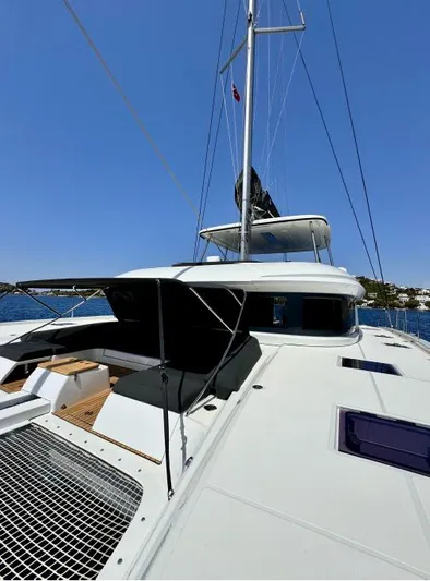  Yacht Photos Pics 2023 Lagoon 55 yacht on calm water, showcasing sleek design and spacious deck.