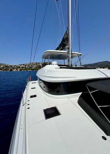  Yacht Photos Pics 2023 Lagoon 55 yacht sailing on clear blue waters under a sunny sky.