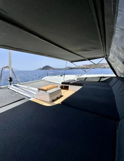  Yacht Photos Pics 2023 Lagoon 55 yacht deck with sunshade, overlooking serene ocean and distant island.