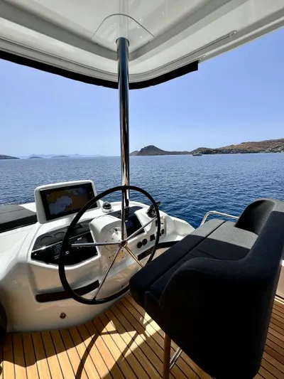  Yacht Photos Pics 2023 Lagoon 55 yacht helm with ocean view, featuring modern navigation equipment.