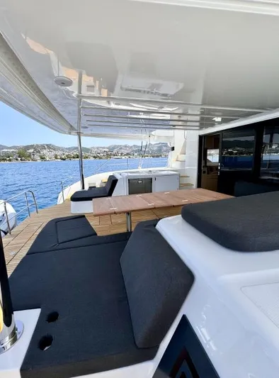  Yacht Photos Pics 2023 Lagoon 55 yacht deck with seating, table, and ocean view.
