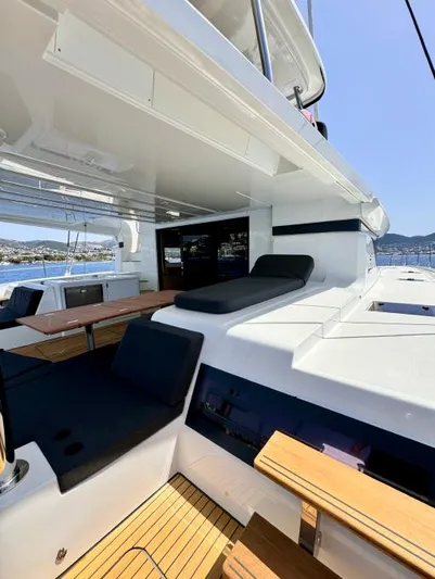  Yacht Photos Pics 2023 Lagoon 55 yacht deck with seating and scenic ocean view.