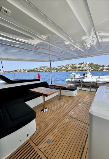  Yacht Photos Pics Luxury Lagoon 55 yacht deck with seating, wooden flooring, and scenic ocean view, 2023 model.