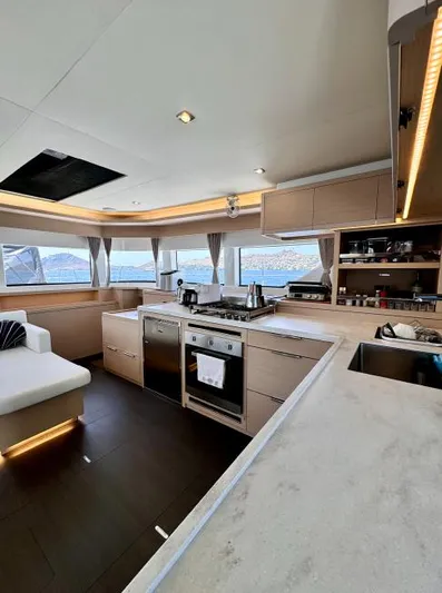  Yacht Photos Pics Luxurious interior of 2023 Lagoon 55 yacht with modern kitchen and panoramic windows.