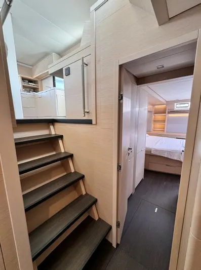  Yacht Photos Pics Interior of 2023 Lagoon 55 yacht, featuring modern stairs and cozy bedroom.