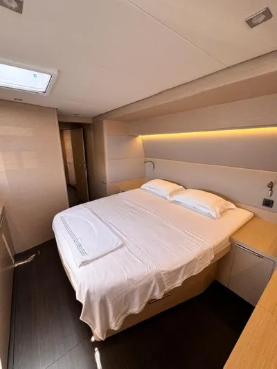  Yacht Photos Pics Luxurious bedroom interior of 2023 Lagoon 55 yacht with modern design and cozy bedding.