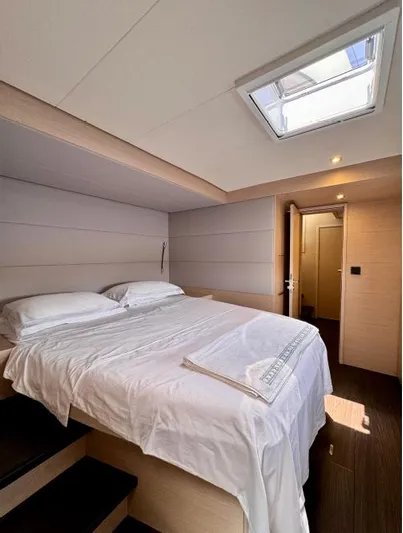  Yacht Photos Pics Luxurious bedroom interior of 2023 Lagoon 55 yacht with skylight and modern design.