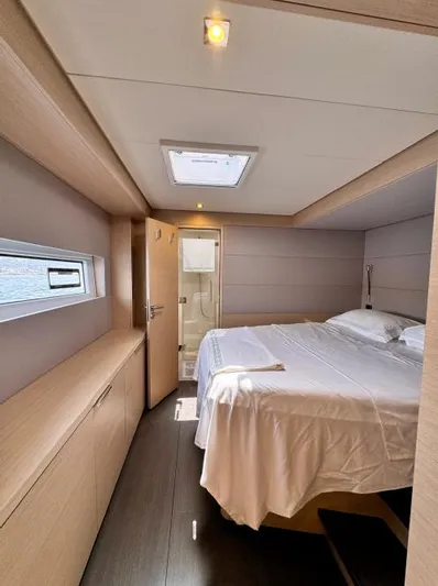 Yacht Photos Pics Luxurious bedroom interior of 2023 Lagoon 55 yacht with modern design and natural lighting.