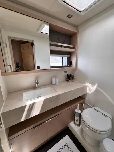  Yacht Photos Pics Modern bathroom in 2023 Lagoon 55 yacht with sleek fixtures and natural lighting.