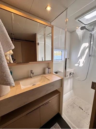  Yacht Photos Pics Modern bathroom in 2023 Lagoon 55 yacht with shower, sink, and mirror.