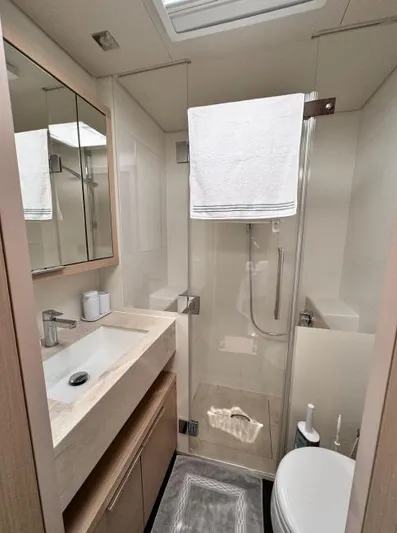  Yacht Photos Pics Modern bathroom in 2023 Lagoon 55 yacht with shower, sink, and toilet.