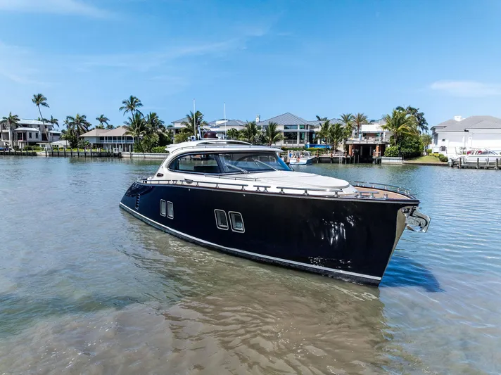A. Noochette Yacht Photos Pics 2024 Zeelander Z5 yacht cruising in a scenic coastal area with palm trees and houses.
