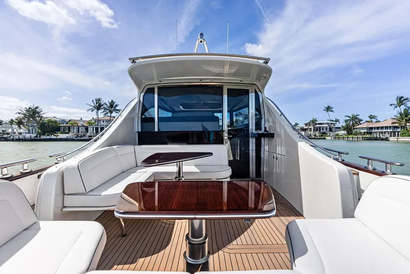 A. Noochette Yacht Photos Pics 2024 Zeelander Z5 yacht with luxurious deck seating and table, set against a scenic waterfront.