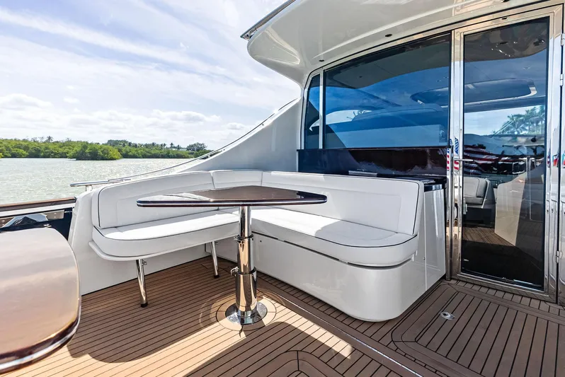 A. Noochette Yacht Photos Pics 2024 Zeelander Z5 yacht deck with elegant seating and table, overlooking serene waters.