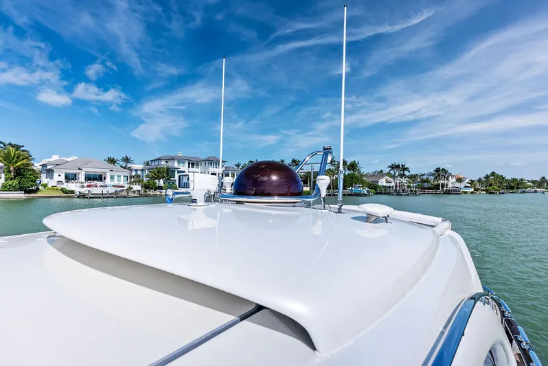 A. Noochette Yacht Photos Pics 2024 Zeelander Z5 yacht on serene water with blue sky and coastal homes.