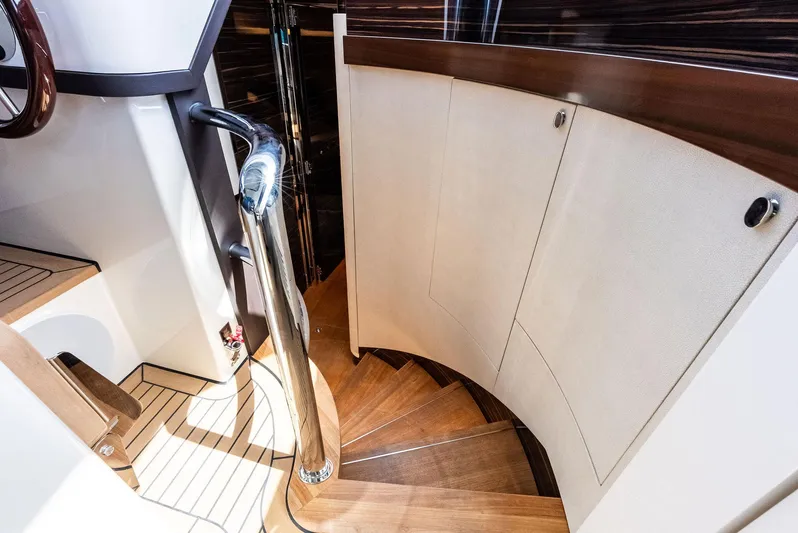 A. Noochette Yacht Photos Pics 2024 Zeelander Z5 yacht interior with elegant wooden spiral staircase and polished metal railing.