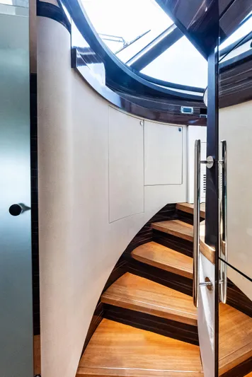 A. Noochette Yacht Photos Pics Curved wooden staircase inside 2024 Zeelander Z5 yacht, featuring sleek modern design.