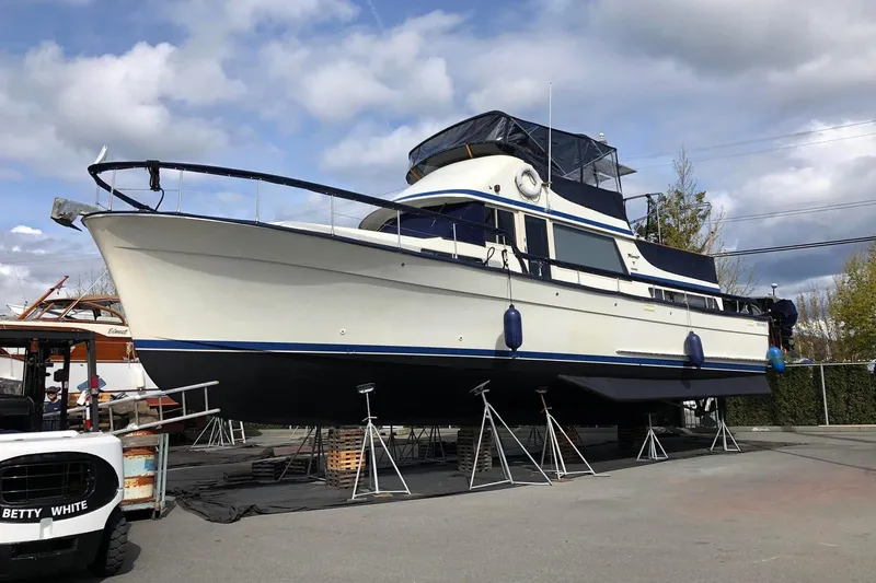 Rose Petal Yacht Photos Pics 1981 Tollycraft 48 Cockpit Motor Yacht on dry dock under cloudy sky.