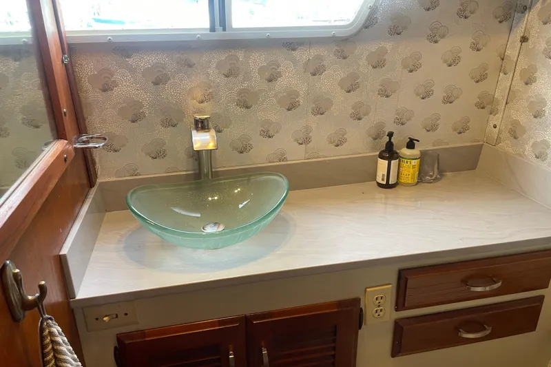 Rose Petal Yacht Photos Pics 1981 Tollycraft 48 Cockpit Motor Yacht bathroom with glass sink and decorative wallpaper.