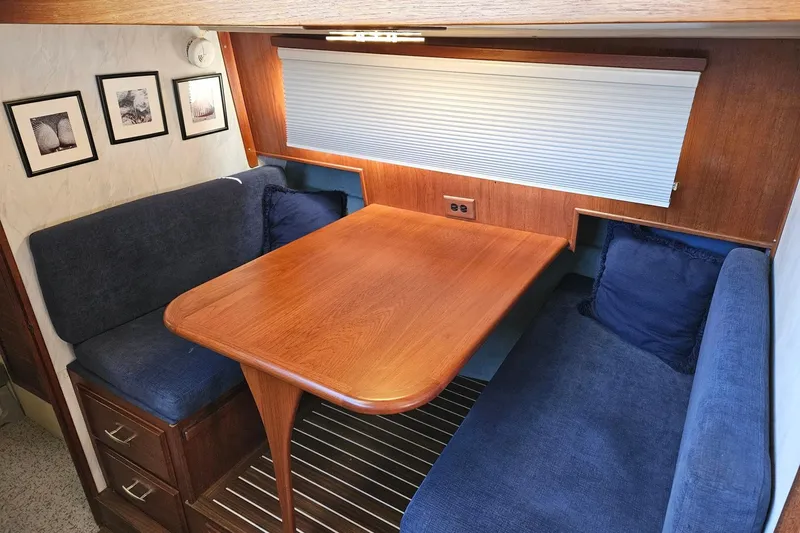 Rose Petal Yacht Photos Pics 1981 Tollycraft 48 Cockpit Motor Yacht interior with wooden table and blue seating.