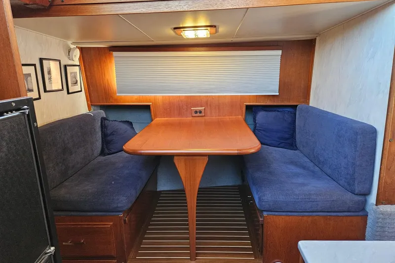 Rose Petal Yacht Photos Pics 1981 Tollycraft 48 Cockpit Motor Yacht interior with cozy dining area and blue seating.