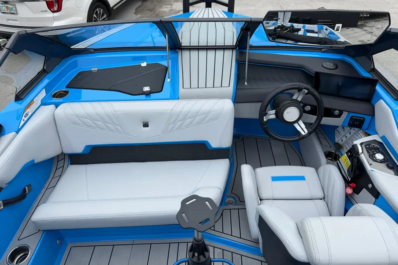  Yacht Photos Pics 2026 Nautique Ski Nautique interior with blue and white seating, modern dashboard, and steering wheel.