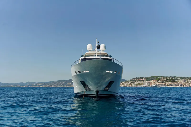 Sea Bear Yacht Photos Pics Luxury yacht Benetti 93 Delfino 2013 on open sea with coastal backdrop.