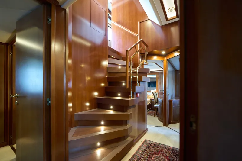 Sea Bear Yacht Photos Pics Luxurious wooden staircase interior on 2013 Benetti 93 Delfino yacht, featuring elegant lighting.