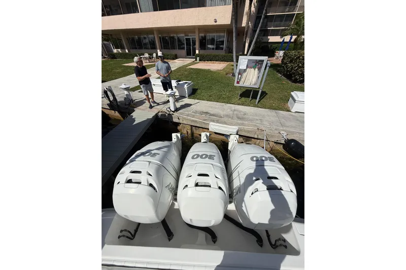  Yacht Photos Pics 2010 Intrepid 323 Cuddy with triple 300 horsepower engines docked near a building.