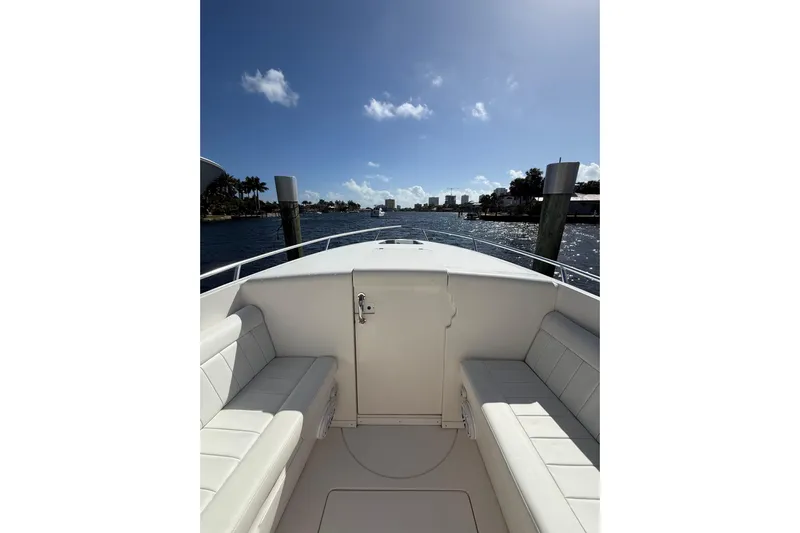  Yacht Photos Pics 2010 Intrepid 323 Cuddy boat interior with white seating, docked on a sunny day.