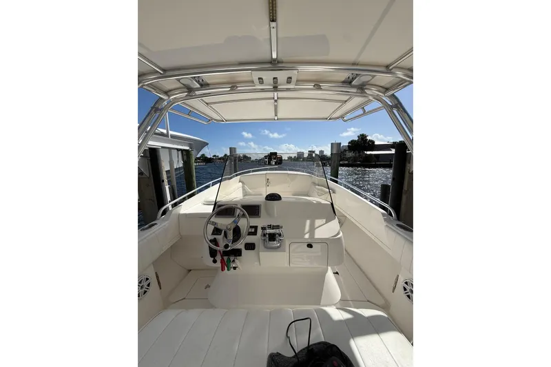  Yacht Photos Pics 2010 Intrepid 323 Cuddy boat interior with steering wheel and waterfront view.