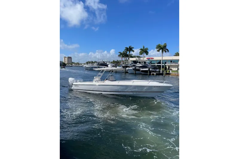  Yacht Photos Pics 2010 Intrepid 323 Cuddy boat cruising on a sunny day near a marina.