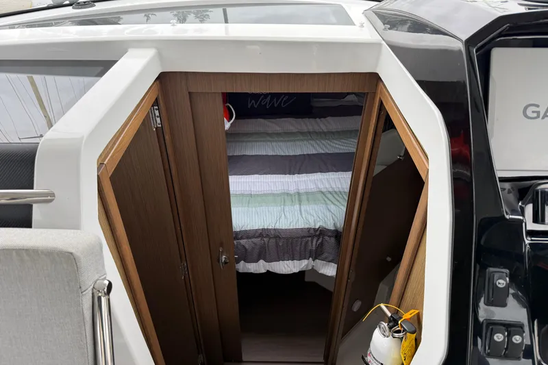  Yacht Photos Pics 2020 Jeanneau NC 895 cabin entrance with striped bedding and wooden doors.