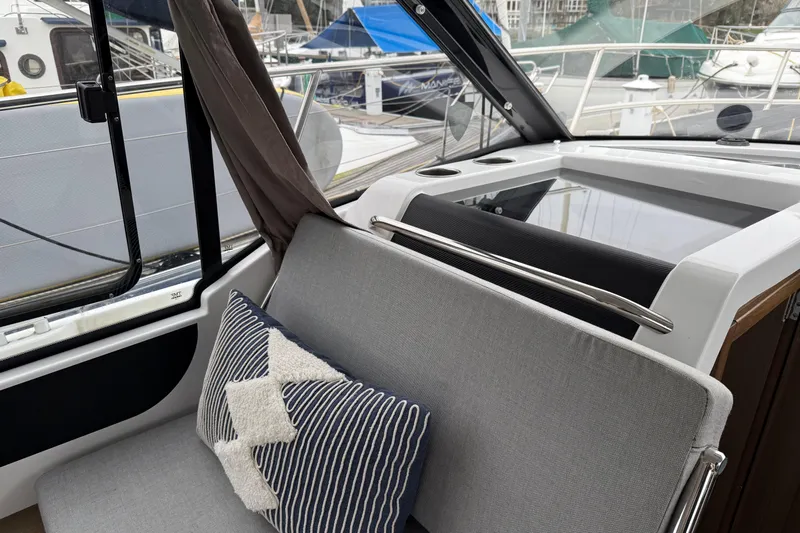  Yacht Photos Pics Interior of 2020 Jeanneau NC 895 boat with cushioned seating and decorative pillows.