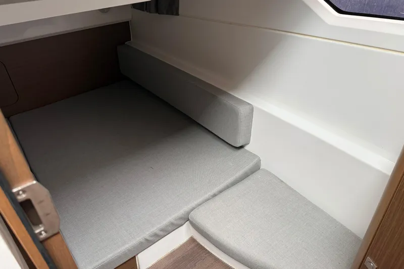  Yacht Photos Pics Cozy cabin interior of 2020 Jeanneau NC 895 with gray cushions and wooden accents.
